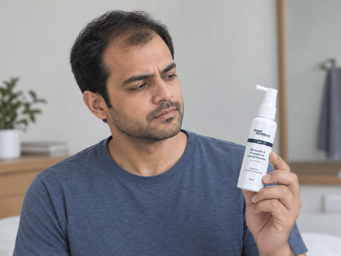 Man examining Man Matters minoxidil and finasteride topical solution for hair regrowth