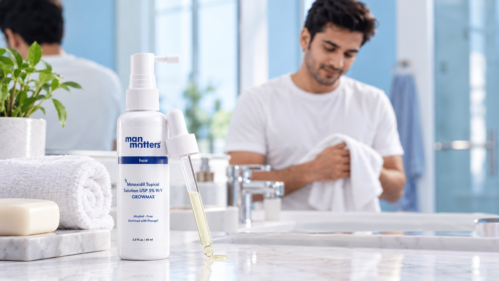 Man applying topical minoxidil solution to his scalp for hair regrowth